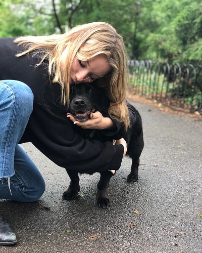 A picture of Madelaine West Duchovny petting a cute dog.